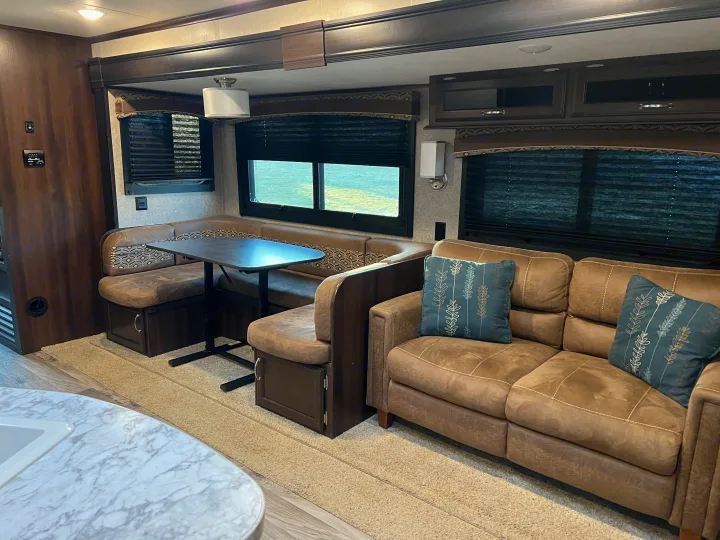 Spacious RV rental living area with comfy U-shaped dinette, sofa, and ample natural light. Ideal for family trips.. Jayco Jay Flight 2018