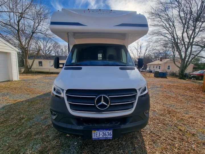 Front of a white Entegra Coach RV rental on a Mercedes-Benz Sprinter chassis, parked in a sunny yard with trees.. Entegra Qwest SE 2025 Qwest 2025 Mercdes-Benz 2025