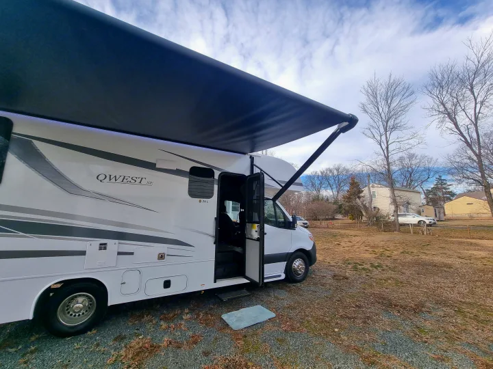 White QWEST RV rental with awning extended, parked outdoors. Perfect for travel and adventure.. Entegra Qwest SE 2025 Qwest 2025 Mercdes-Benz 2025