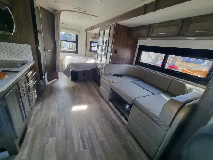Spacious RV rental interior featuring a modern living area, kitchen, and cozy bedroom with wood-look flooring.. Entegra Qwest SE 2025 Qwest 2025 Mercdes-Benz 2025