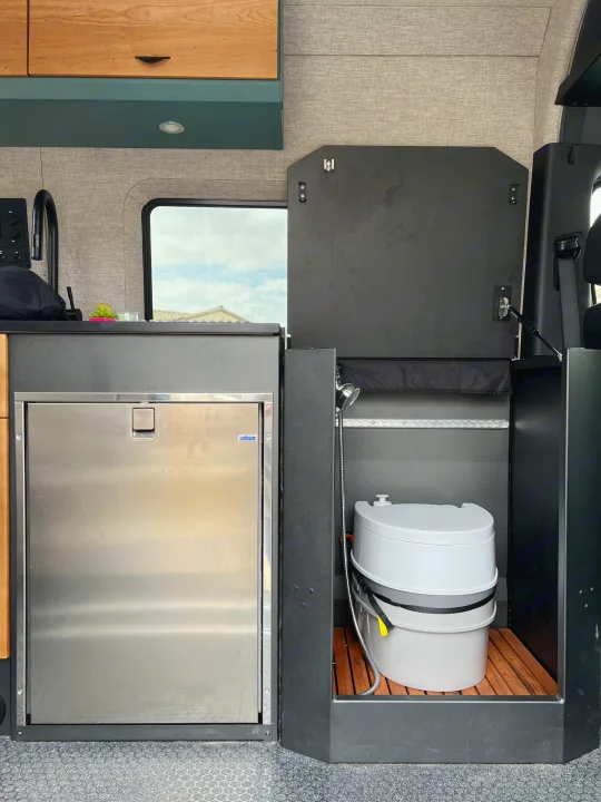 RV rental: Compact camper van interior with fridge, sink, and integrated portable toilet/shower.. Off Highway Van Off Highway Van Class B 2024