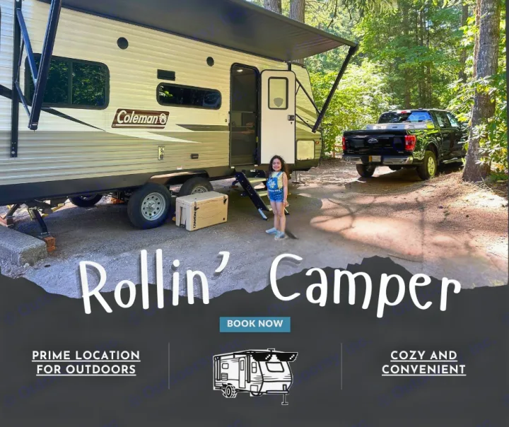Experience our RV rental! A cozy camper trailer is set up at a prime wooded campsite with a little girl and pickup truck, perfect for outdoor adventures.. Dutchmen Coleman Lantern LT 2021