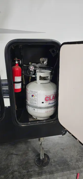 Propane tank and fire extinguisher in an RV rental storage compartment. Essential safety for your trip!. Forest River Sabre 2019