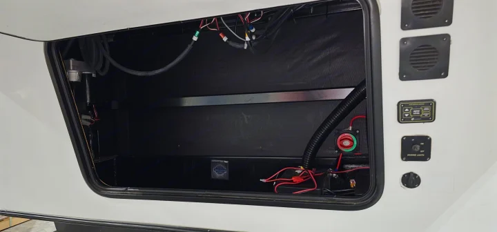 RV rental storage bay reveals essential electrical systems, battery disconnect, auto-level, and docking light controls.. Forest River Sabre 2019