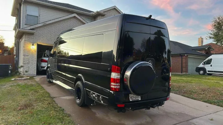 A sleek black Mercedes Sprinter van, perfect for RV rental, parked in a residential driveway at dusk.. Midwest Automotive Designs Midwest Automotive Designs Class B 2016