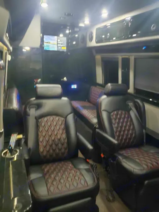 Plush black leather diamond-quilted seats and a TV fill this premium RV rental interior, ready for travel.. Midwest Automotive Designs Midwest Automotive Designs Class B 2016