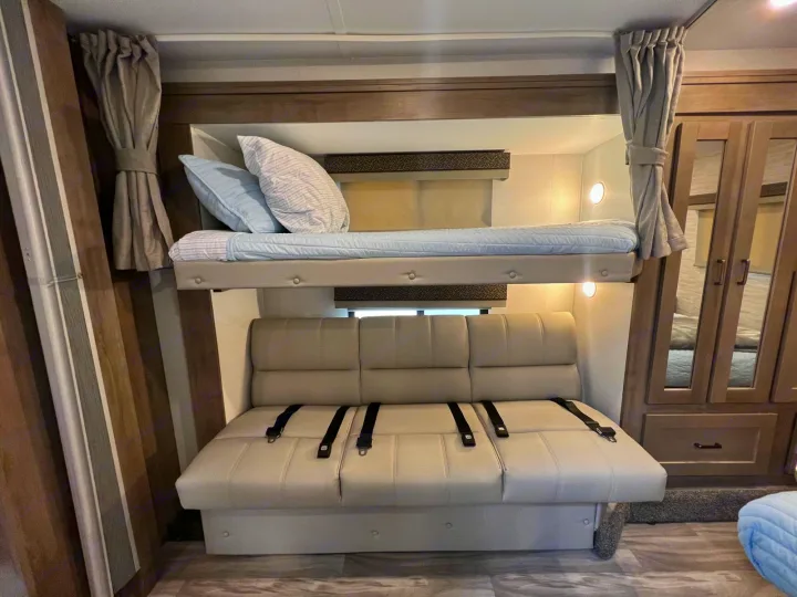 This RV rental features a flexible interior with a lower sofa bed (with seatbelts) and an upper bunk bed for versatile sleeping.. Gulf Stream Conquest 2025