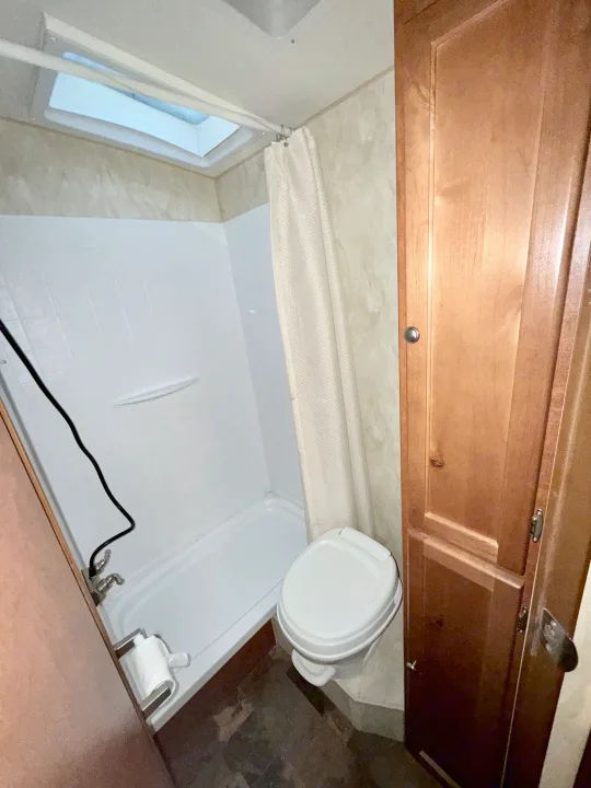 RV rental: A compact bathroom featuring a shower, toilet, and wood cabinets, complete with a skylight.. Nash Nash Trailer 2016