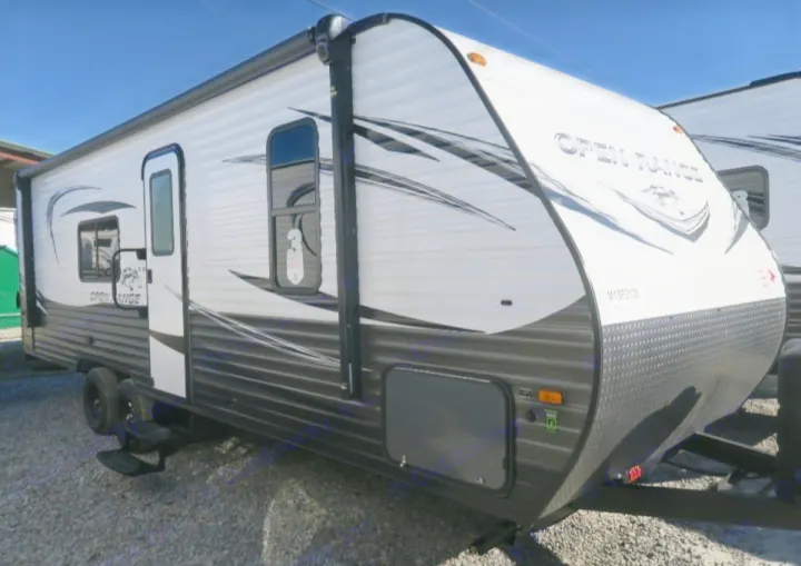 This white and grey Open Range travel trailer is perfect for your next RV rental adventure. Parked on a gravel lot.. Open Range Open Range 2021