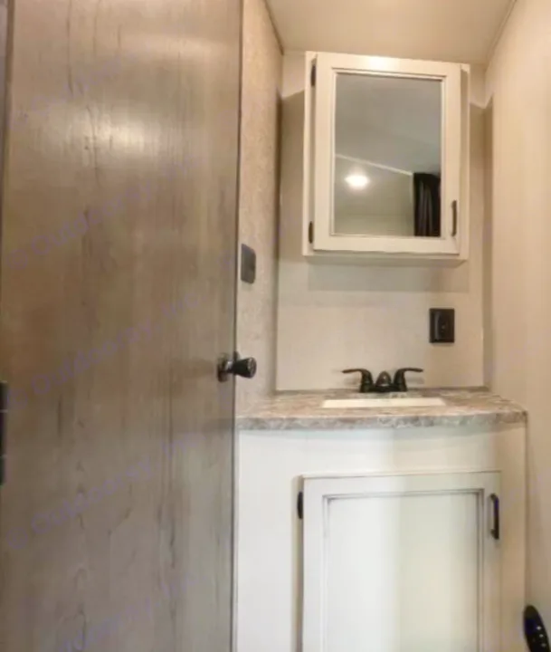 View of a functional RV rental bathroom vanity, featuring a sink, faucet, countertop, and mirrored medicine cabinet.. Open Range Open Range 2021