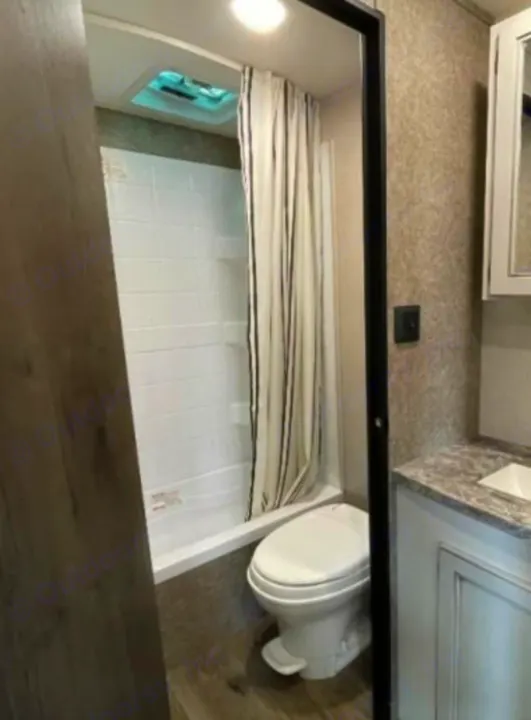 Compact RV rental bathroom with shower, toilet, and vanity, designed for comfortable travel.. Open Range Open Range 2021