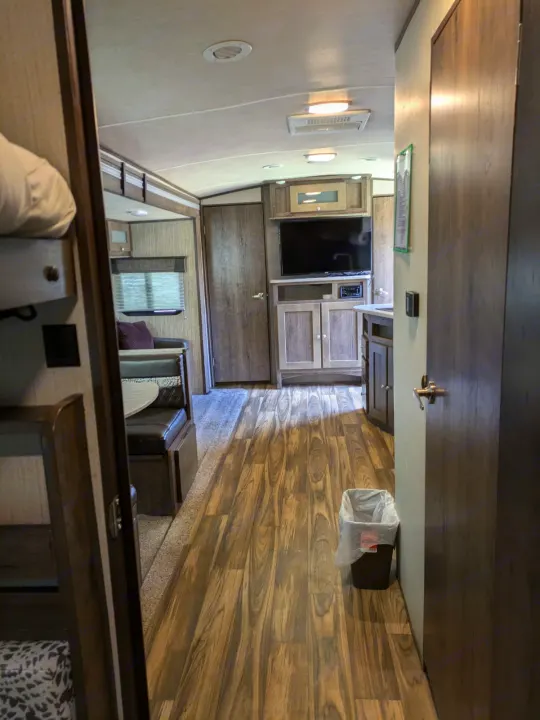 Inside this modern RV rental: a comfortable living space with a dinette, entertainment, and bunk beds.. Cruiser RV MPG Ultra Lite 2019
