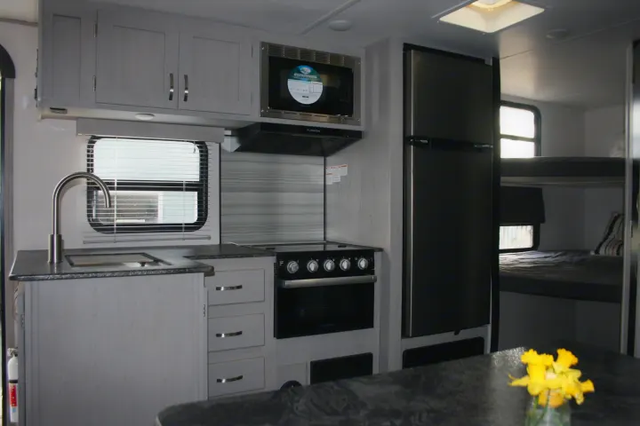 Spacious RV rental interior: modern kitchen, fridge, and cozy bunk beds. Perfect for family adventures.. Forest River Tracer 2022