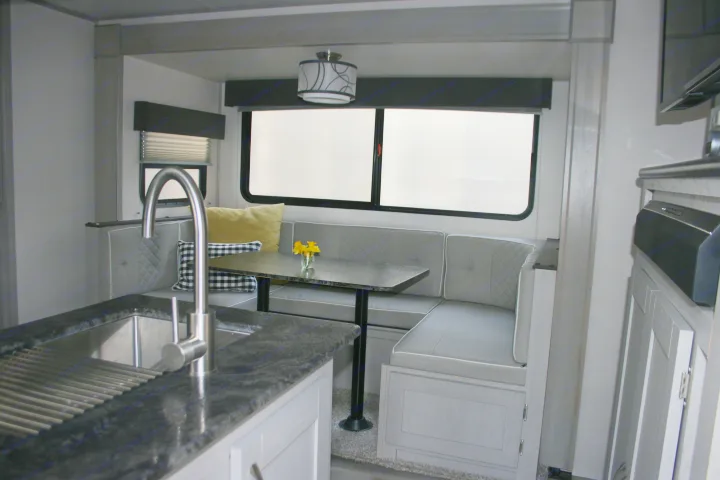 Enjoy this RV rental's cozy dinette & kitchen. Features a full sink, comfy cushions, & ample light.. Forest River Tracer 2022