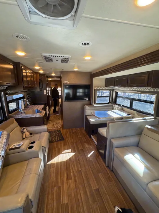 Bright and spacious RV rental interior showcasing a full kitchen, comfortable living area, and dinette.. Thor A.C.E. 2019