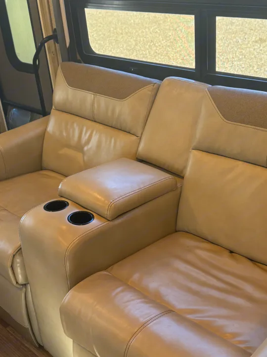 A view of comfortable tan leather recliners with cup holders in an **RV rental** living area.. Thor A.C.E. 2019