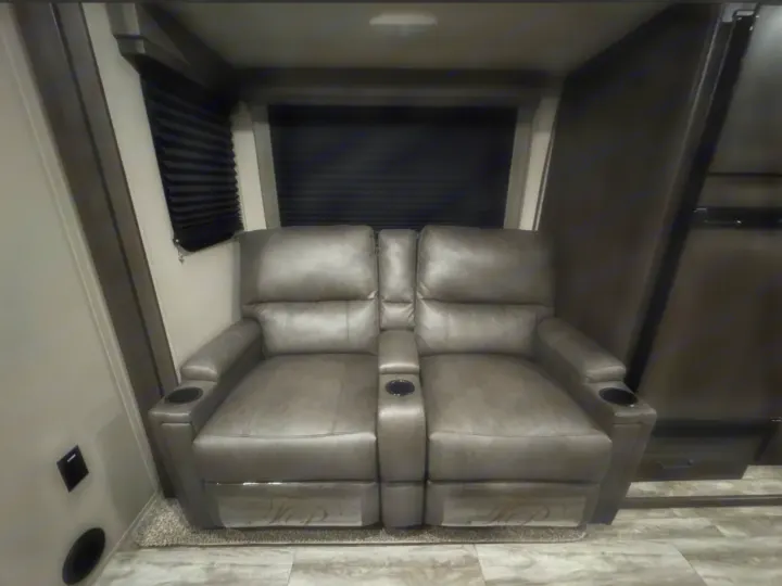 Comfortable gray recliners with cup holders offer luxury theater seating in this RV rental, ideal for relaxing.. Grand Design Transcend Xplor 2022