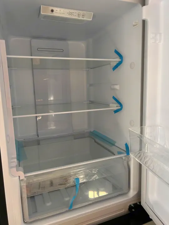 Spacious, clean RV rental refrigerator interior, empty and ready for your provisions, showing shelves and crisper.. Forest River Sunseeker 2025