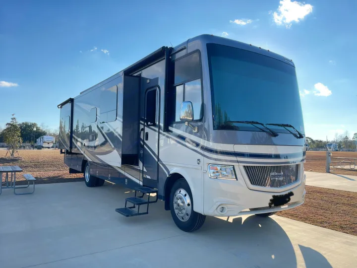 Spacious Newmar RV rental ready for adventure at a sunny campsite, with slide-outs extended and steps down.. Canyon Star Canyon Star Motorhome 2020