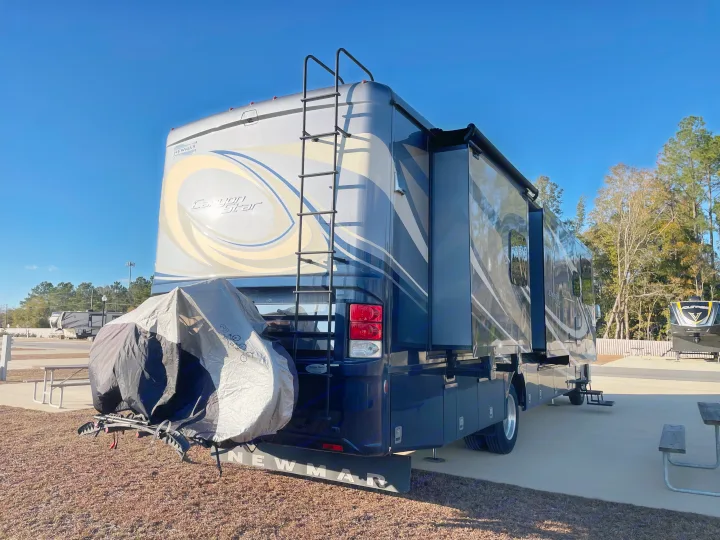 Spacious Newmar Canyon Star RV rental with bikes on the back, parked under a clear sky at a bright RV park, ready for adventure.. Canyon Star Canyon Star Motorhome 2020