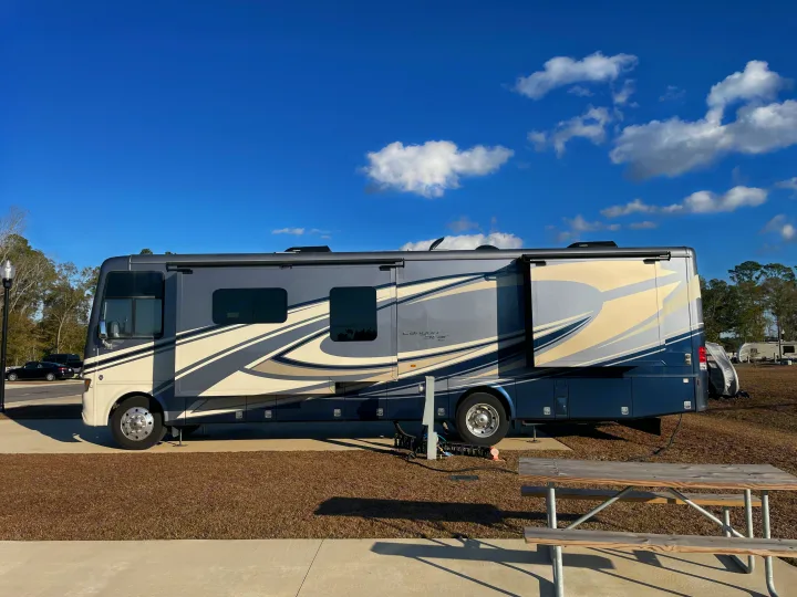 Explore the outdoors with an RV rental. This spacious motorhome is parked at a sunny campsite, complete with a picnic table.. Canyon Star Canyon Star Motorhome 2020