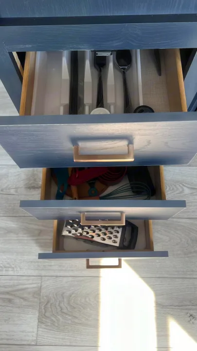 RV rental kitchen with open drawers. Cutlery, cooking utensils, and a grater are neatly stored.. Prime Time Avenger 2024