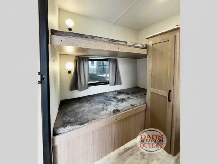 RV rental interior showing bunk beds, a window with curtains, and a wooden wardrobe. Great for family adventures.. Gulf Stream Innsbruck 2024