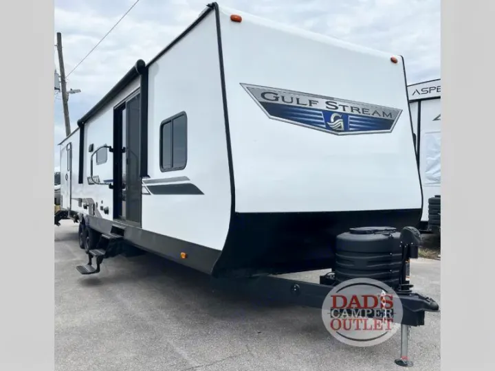 White Gulf Stream travel trailer, ideal for RV rental adventures. Features a large side door and awning. From Dad's Camper Outlet.. Gulf Stream Innsbruck 2024