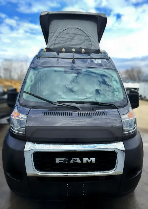 Front view: Rainy dark grey Ram ProMaster camper van with pop-top roof, ready for your next RV rental adventure.. Winnebago Solis 2021