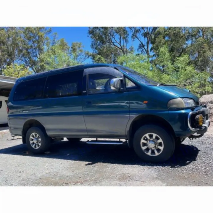 Off-road Mitsubishi Delica 4x4 van, ready for an rv rental adventure, parked on gravel with trees in the background.. MITSUBISHI Delica 1997