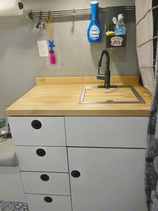 RV rental kitchen: compact sink, wood counter, and storage with essentials like Dawn soap.. Ford Custom Transit 2019
