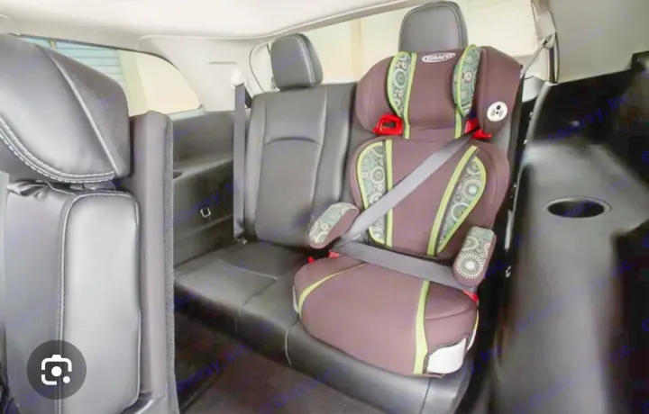 Rear view of a clean SUV interior with a brown & green Graco child booster seat, perfect for your RV rental journey.. Dodge Journey 2016