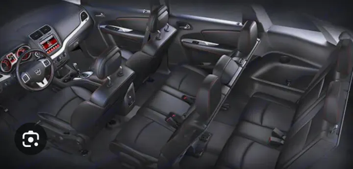 View of a spacious car interior with three rows of black seats, perfect for a family RV rental alternative. Dodge Journey 2016