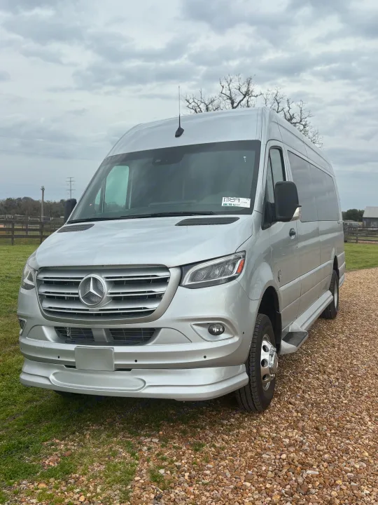 Silver Mercedes-Benz Sprinter RV rental, a modern camper van parked on a gravel path ready for adventure.. Mercedes-Benz OG Luxury Coach V Cruis 2025