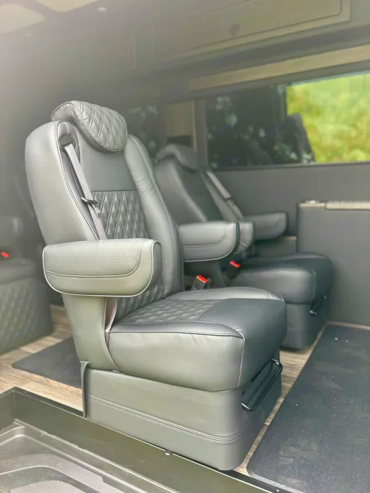 Comfortable black leather captain's chairs with diamond quilting & armrests inside this luxury RV rental.. Mercedes-Benz OG Luxury Coach V Cruis 2025