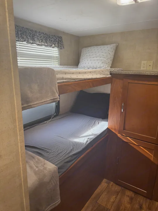 RV rental bunk beds with cozy bedding and natural light.. Keystone RV Passport Grand Touring 2014