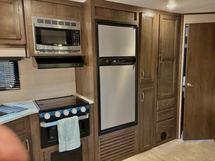 Spacious RV rental kitchen with microwave, fridge, stove/oven, and ample storage for your travels.. Jayco Jay Flight SLX 2021