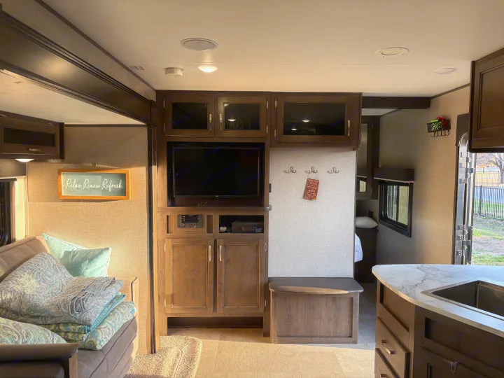 Spacious RV rental living area featuring a TV, sleek cabinetry, and a modern kitchen island.. Jayco Jay Flight SLX 2021