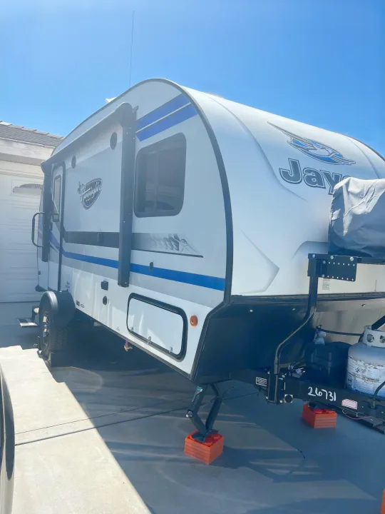 White Jayco Hummingbird travel trailer, an ideal RV rental, parked on a sunny driveway.. Jayco Hummingbird 2019