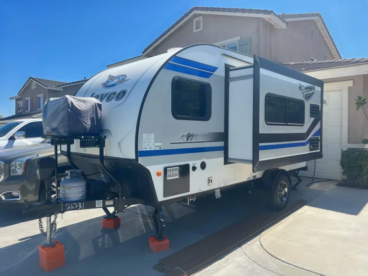 White & blue Jayco travel trailer parked in a sunny driveway, stabilized, perfect for an RV rental.. Jayco Hummingbird 2019