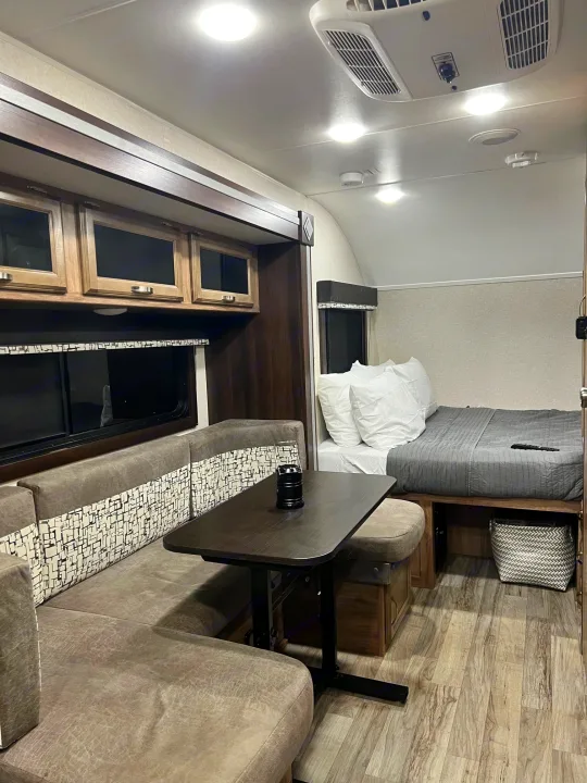 Compact RV rental interior showcasing a modern dinette, bed, and efficient living space for travel.. Jayco Hummingbird 2019