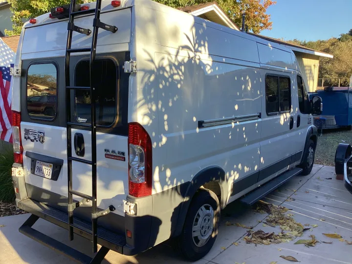 This white Ram ProMaster camper van, ready for your RV rental adventure, features a rear ladder and California plate.. Dodge Ram 1500 2014