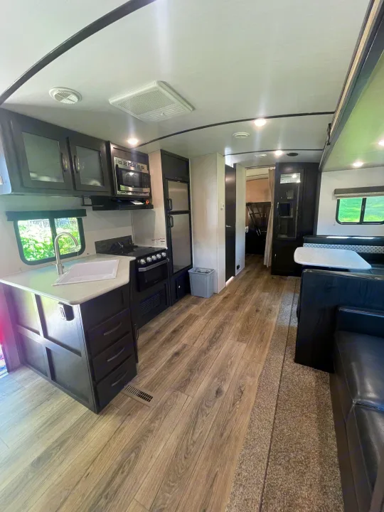 Spacious RV rental interior, showcasing a modern kitchen with appliances, comfortable dining, and ample living space.. Forest River Surveyor Legend 2019