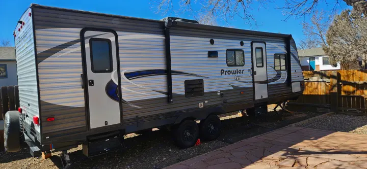 RV rental: Get ready for adventure in this grey and blue striped Prowler Lynx travel trailer, parked on gravel.. Heartland RVs Prowler Lynx 2018