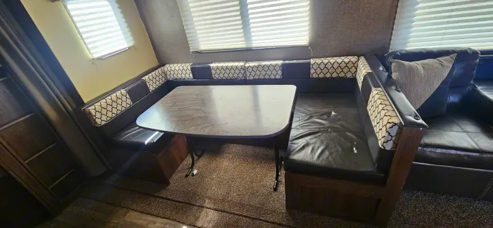 RV rental interior: U-shaped dinette with comfortable patterned seating and a sturdy table. Features a sofa too.. Heartland RVs Prowler Lynx 2018