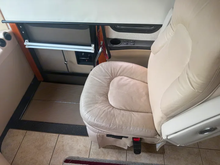 This RV rental features a comfortable cream leather captain's chair, window shades, a control panel, and tiled flooring.. Kountry Star Kountry Star Motorhome 2008