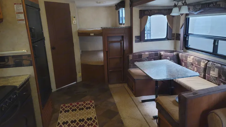 Spacious RV rental interior with kitchen, dinette, and bunk beds. Perfect for family adventures.. Keystone RV Springdale 2012