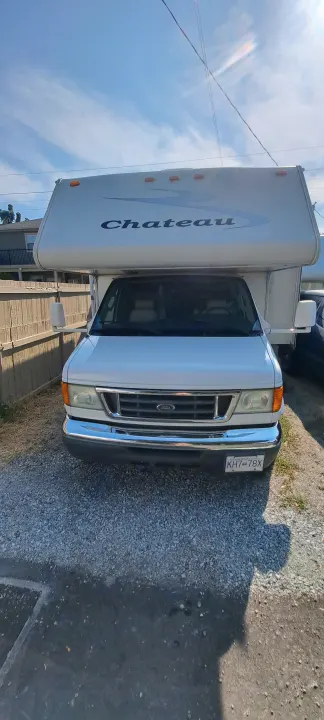 Front view of a white Chateau Class C RV, a Ford motorhome, parked on gravel – an ideal rv rental.. Four Winds Chateau 2007