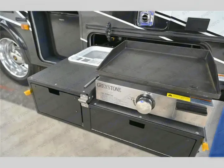 RV rental outdoor kitchen featuring a pull-out sink and Greystone griddle, with built-in storage. Ideal for camping.. Couchmen Entourage 340BH 2025
