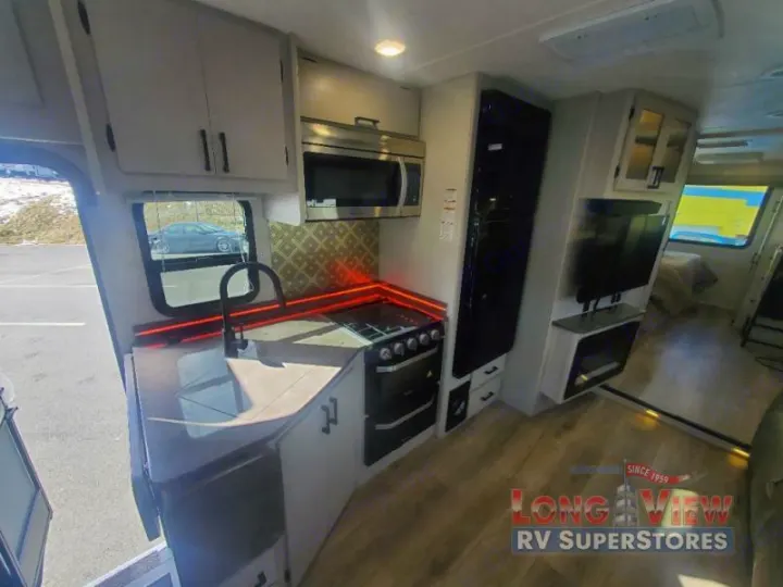 Explore this spacious RV rental interior: a modern kitchen with sink, stove, microwave, plus entertainment and sleeping areas.. Couchmen Entourage 340BH 2025